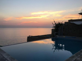 Villa Afros on the waterfront with pool and steps leading to the sea in Koundouros